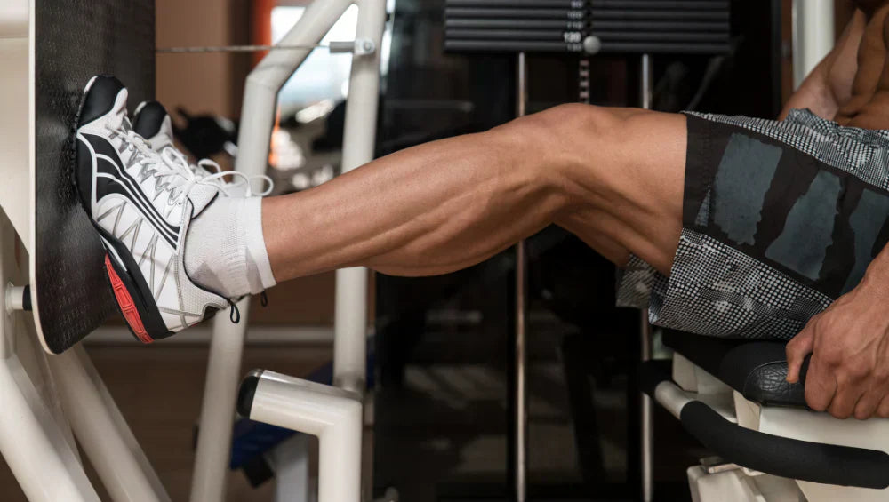 Homme en train d'effectué sur une machine press un exercice solicitant les mollets