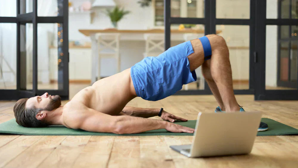 Homme athlétique en train de faire un exercice fessier dans son salon