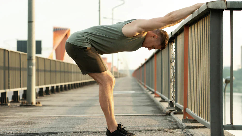 Homme sportif en train de faire un étirement du bas du dos sur un pont