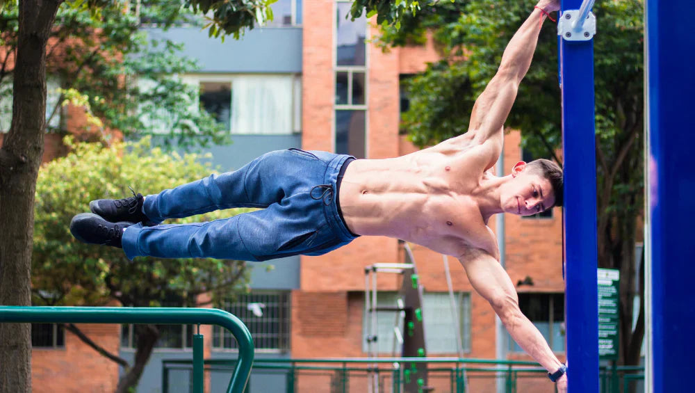 Homme sec et musclé en train d'effectuer de la calisthenics en pleine air