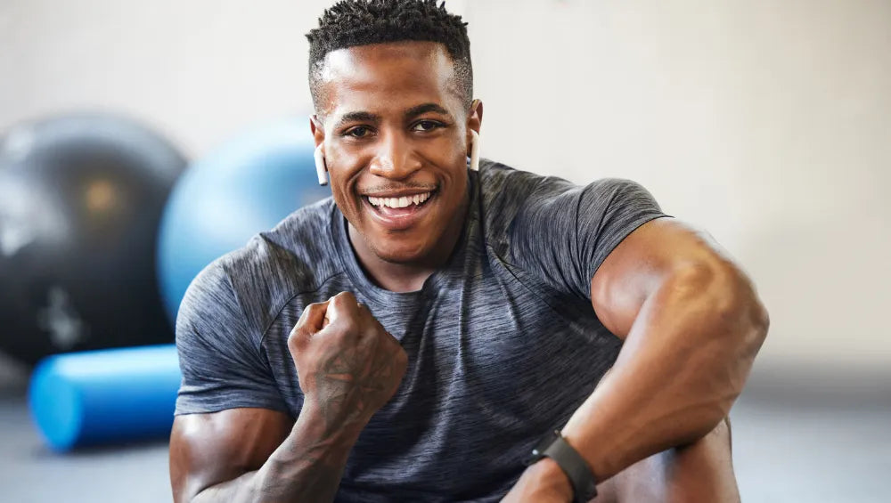 Homme souriant assis dans une salle de gym