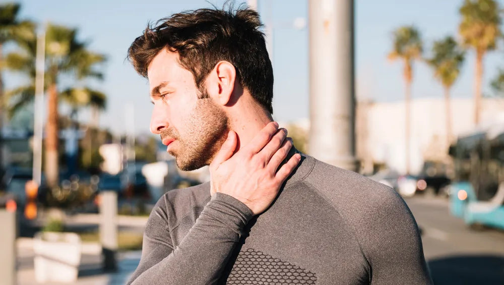 Homme ce tenant le coup d'une main en pleine air