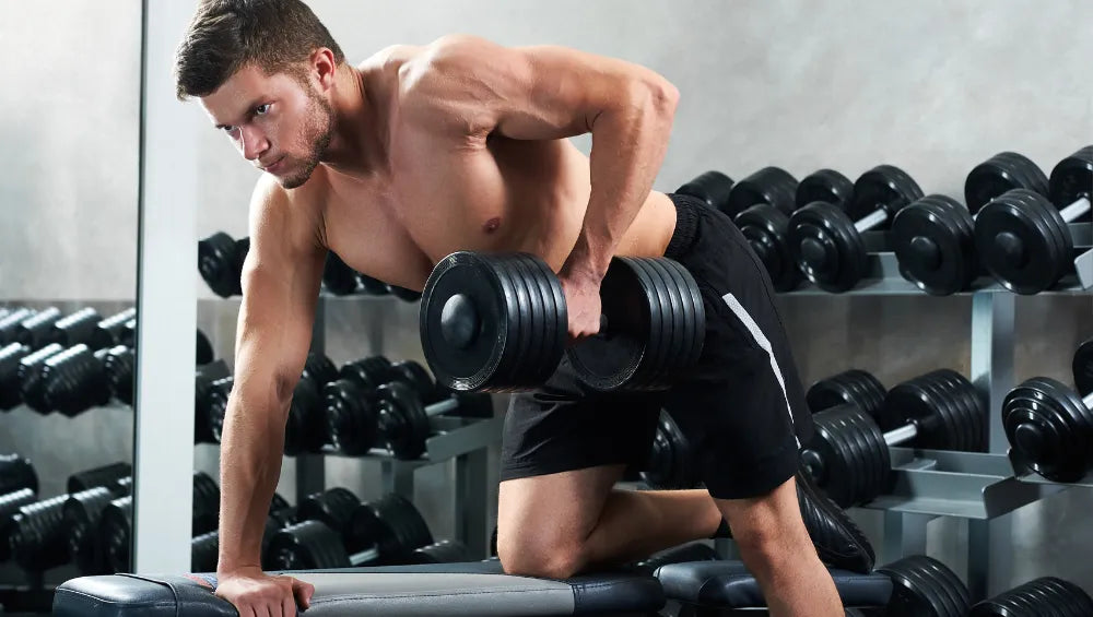 Homme torse nu en train d'effectuer une série de tirage dos au haltère