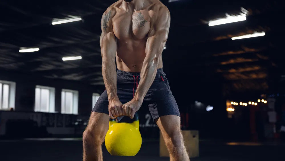 Homme torse nu en train d'effectuer une série au kettlebell