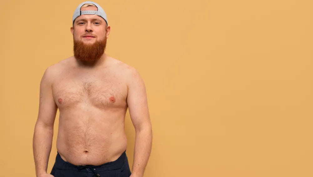 Homme torse nu skinny fat ce tenant debout sur un fond jaune oranger