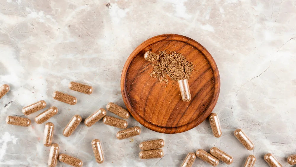 Plusieurs pilules marron sur un couvercle en marbre sur un fond gris en vue du haut