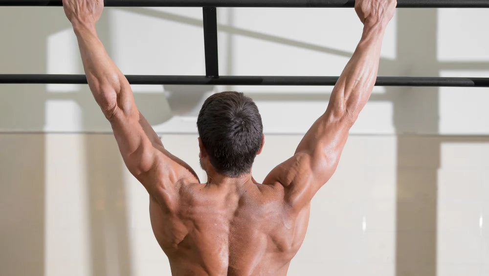 Homme qui s'entraine à faire un muscle up à la barre de traction.