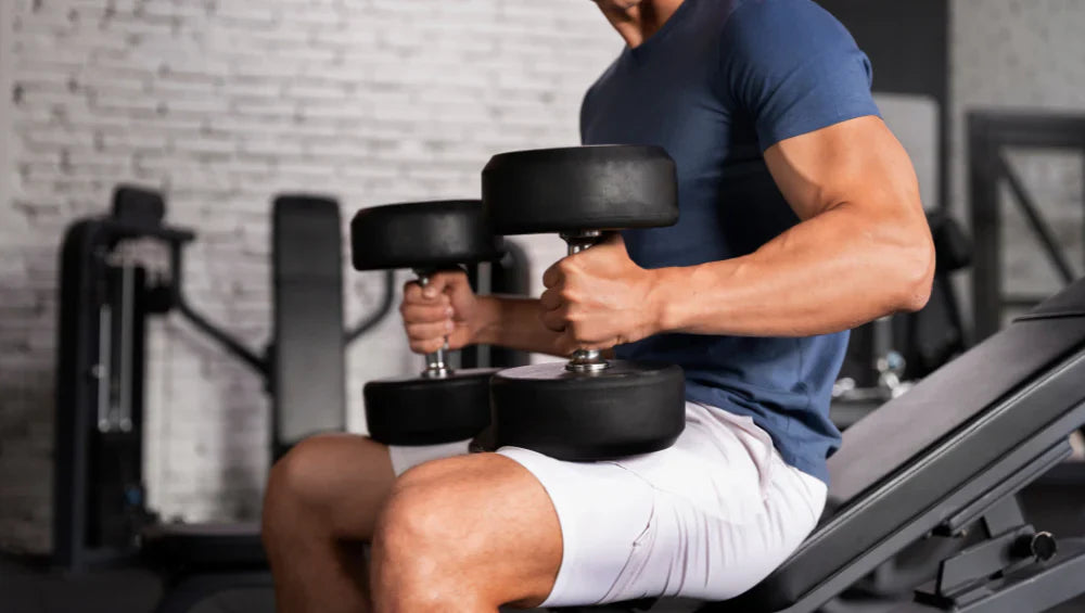 Photo d'un homme qui tient deux haltères à la salle de sport.