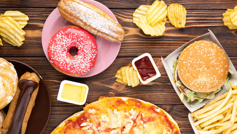 Représentation d'un cheat meal, avec donut, pizza, chips, dessert, burger
