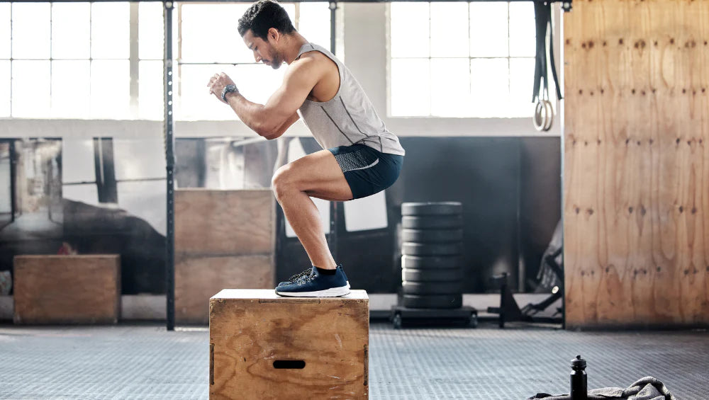 Homme en circuit de cross training, pratiquant un saut sur une box, box jumps