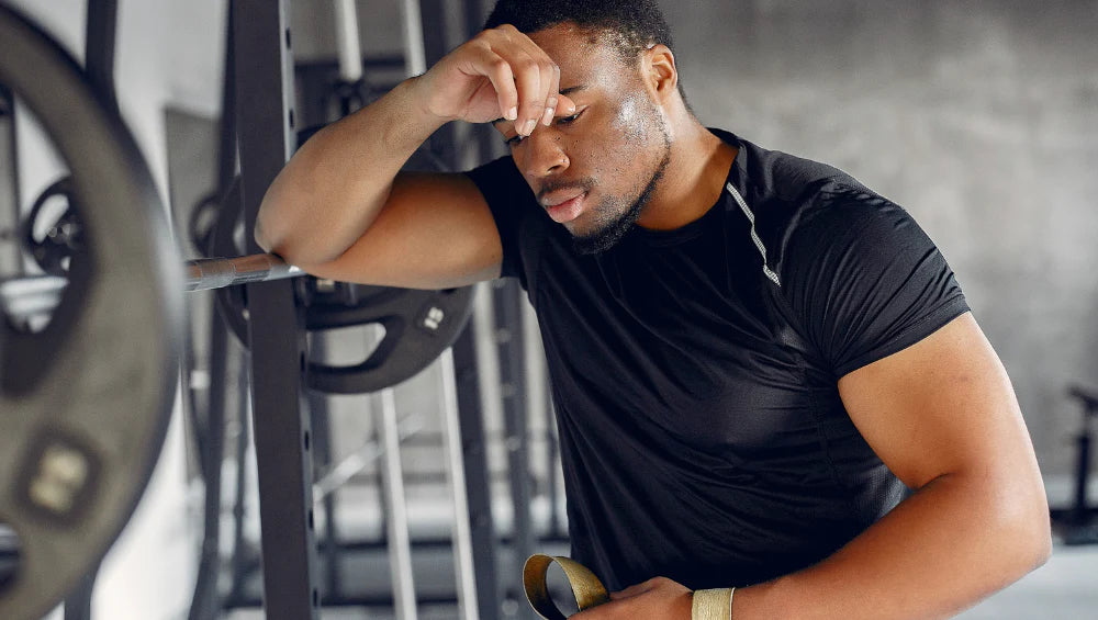 Homme qui a fait une séance à la salle, qui ressent une fatigue musculaire après avoir fait des squat