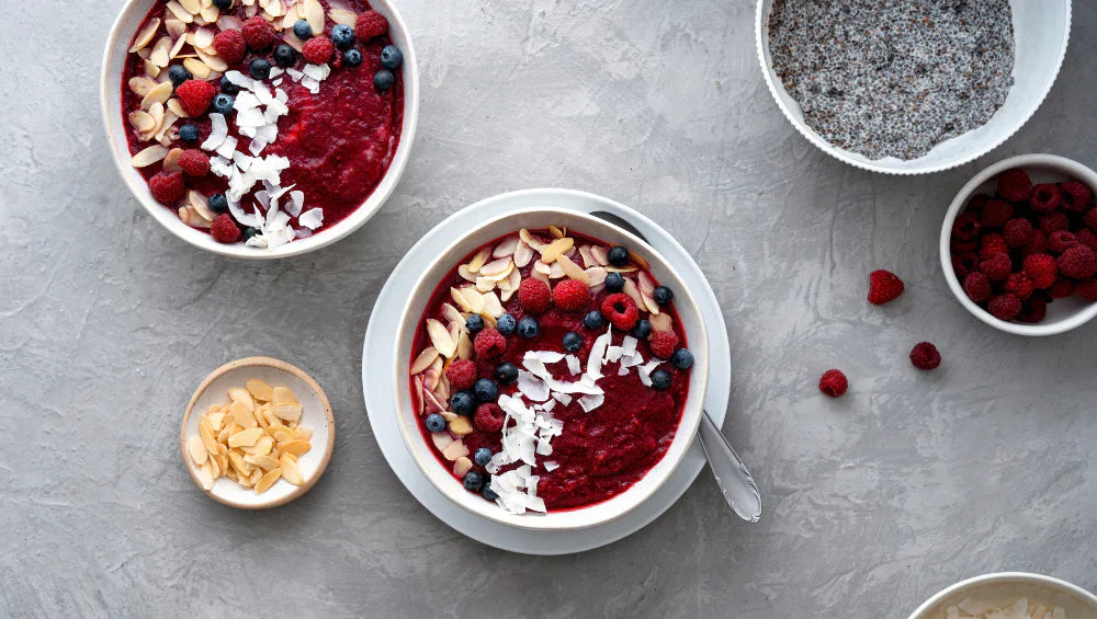 Smoothie bowl présenté sur une table avec vu du dessus avec des fruits rouge a coté
