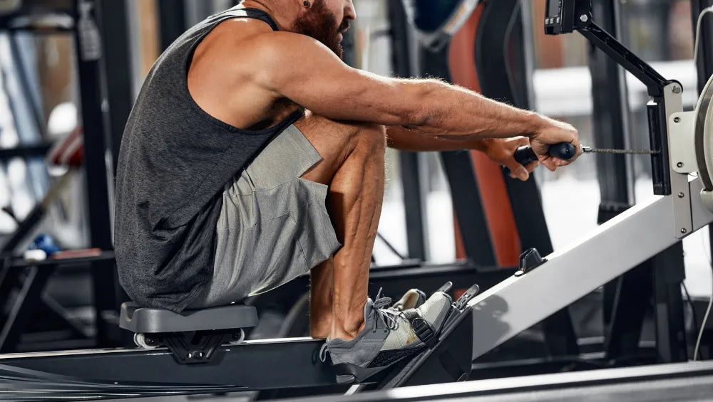 Homme faisant du rameur dans une salle de sport