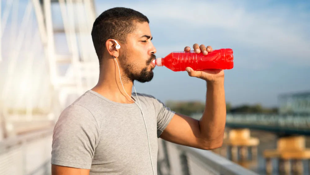 Homme en train de boire dans une bouteille des BCAA