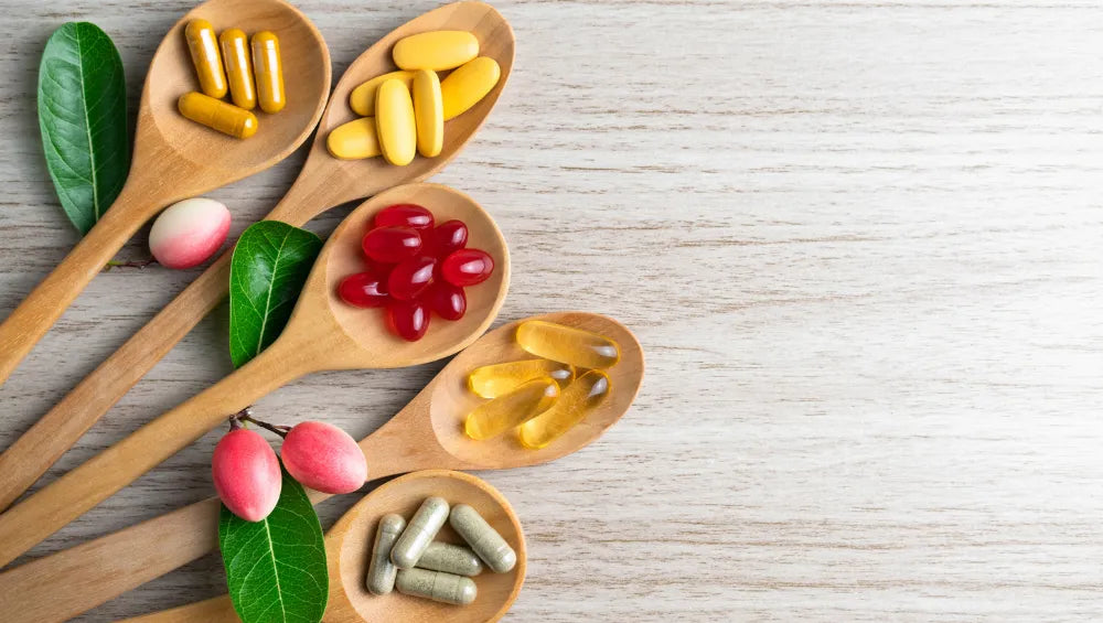 Plusieurs compléments alimentaire vitaminé posé sur des cuillères en bois