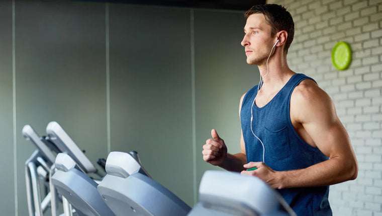 Homme qui court sur un tapis de course à la salle de sport.