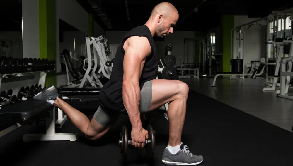 Homme qui fait des fentes pour se muscler les fessiers.