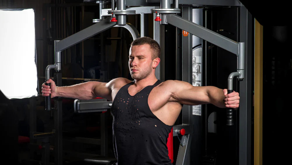 Homme musclé qui fait un exercice de pectoraux à la machine pec deck. 