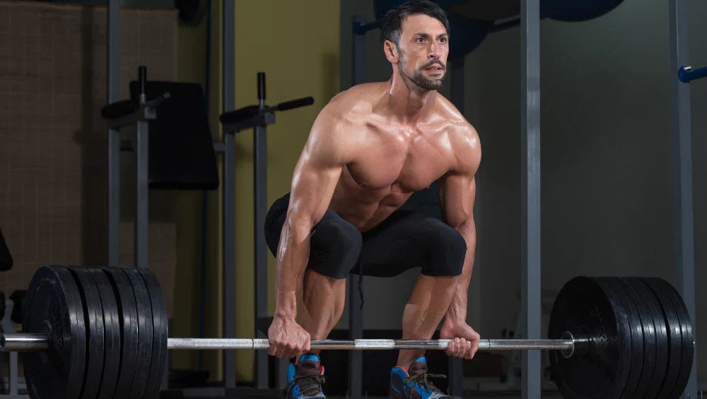 Homme qui fait un soulevé de terre à la salle de sport.