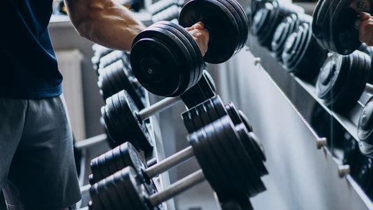 Image d'un homme qui porte un poids (haltère) dans une salle de musculation.