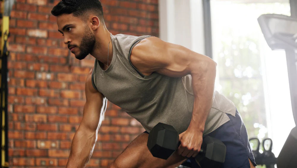 Homme qui fait une séance haut du corps en salle de musculation, pendant la période du Ramadan.
