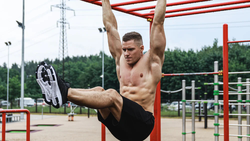 Homme musclé pratiquant du street workout en extérieur.