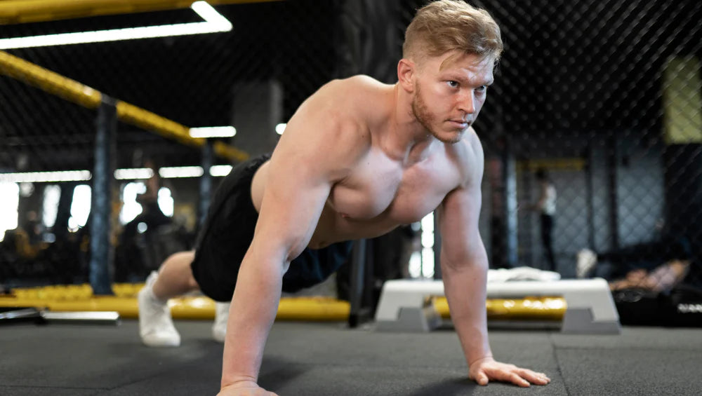 Homme musclé, qui fait des pompes à la salle de sport