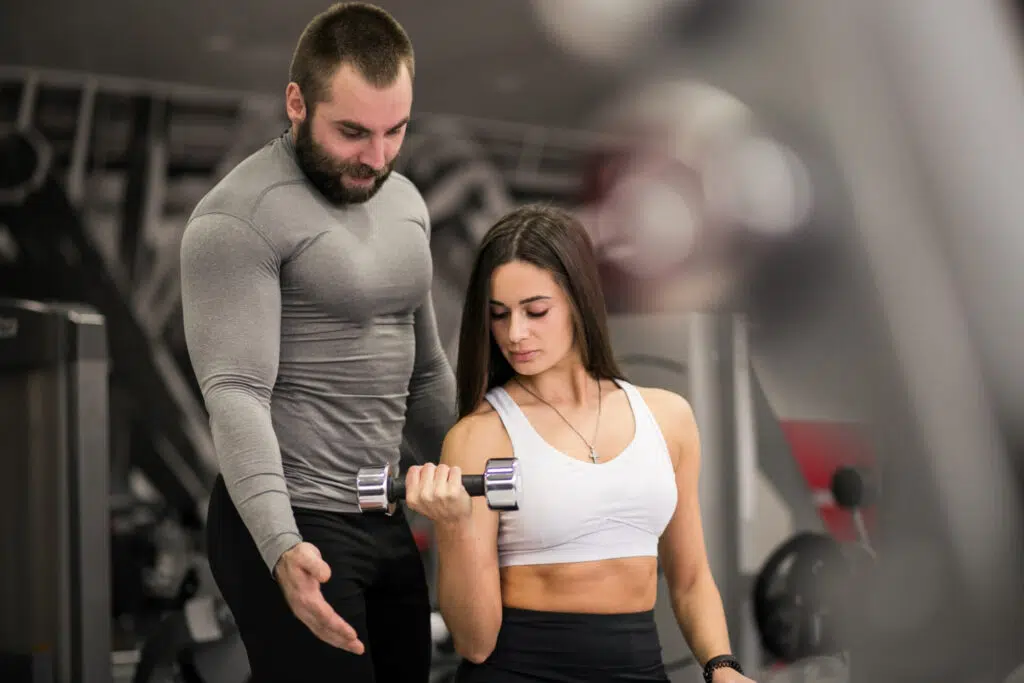 Un homme et une femme en séances de musculation dans une salle de sport