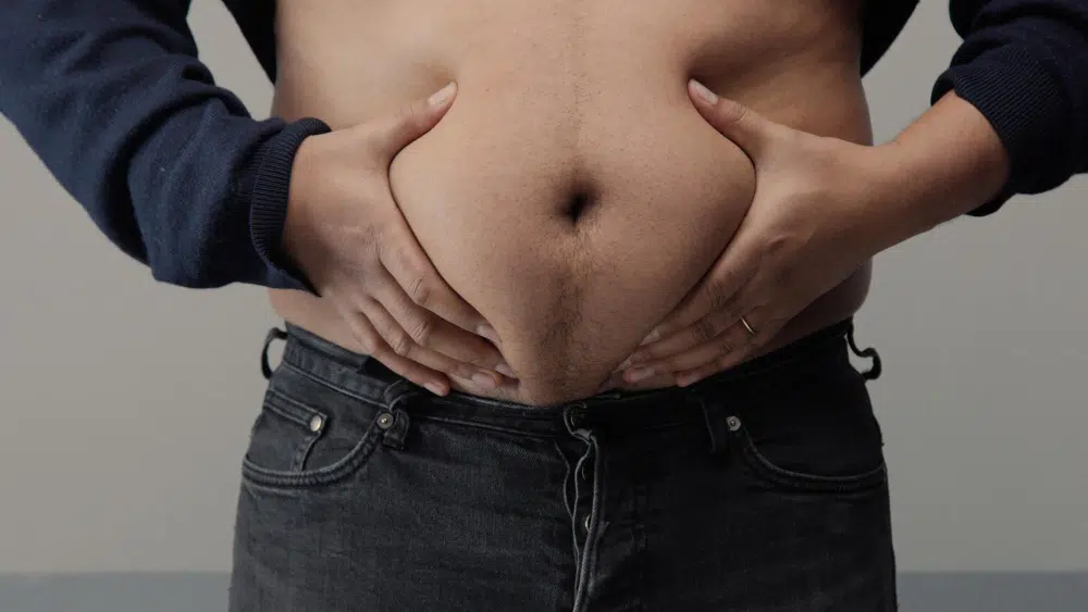 A man holding his big belly